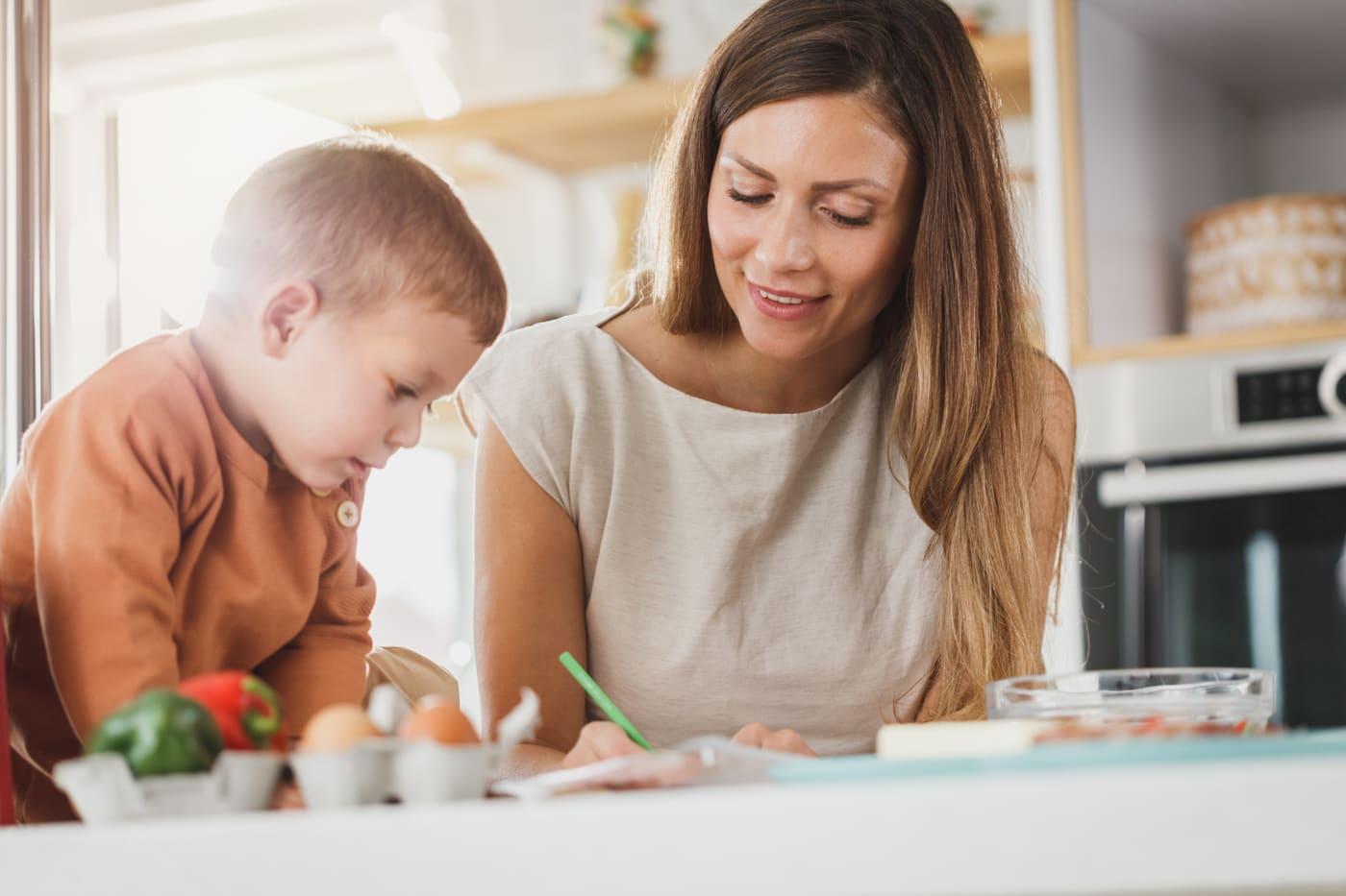 Un adulte accompagne un enfant pendant ses devoirs à la maison