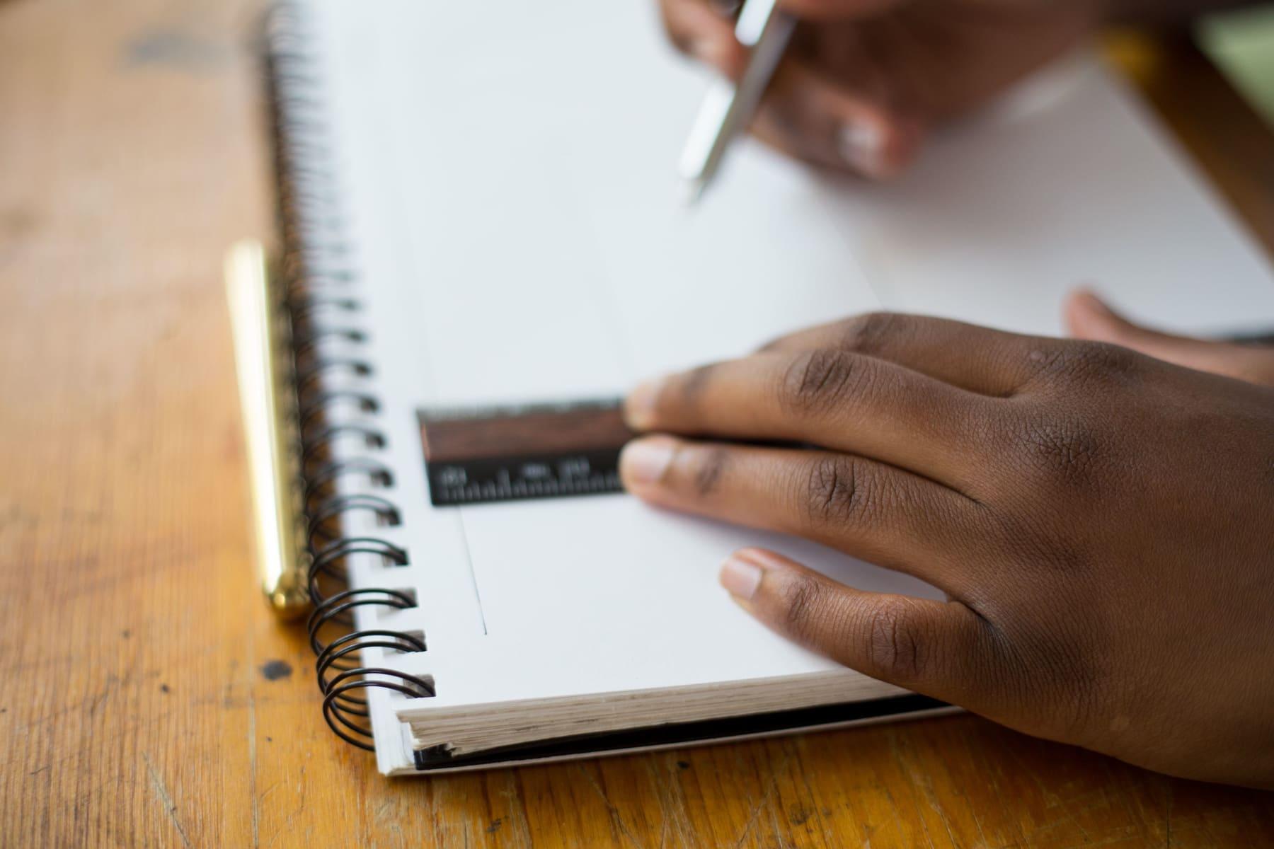 Un collégien trace une figure à la règle dans son cahier