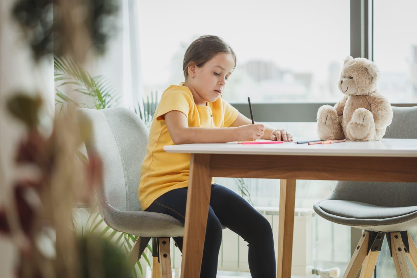 Une élève fait ses devoirs, concentrée sur son cahier