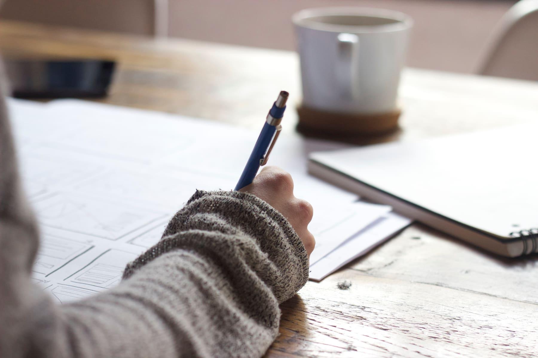 Un élève écrit dans son cahier pendant une séance de travail